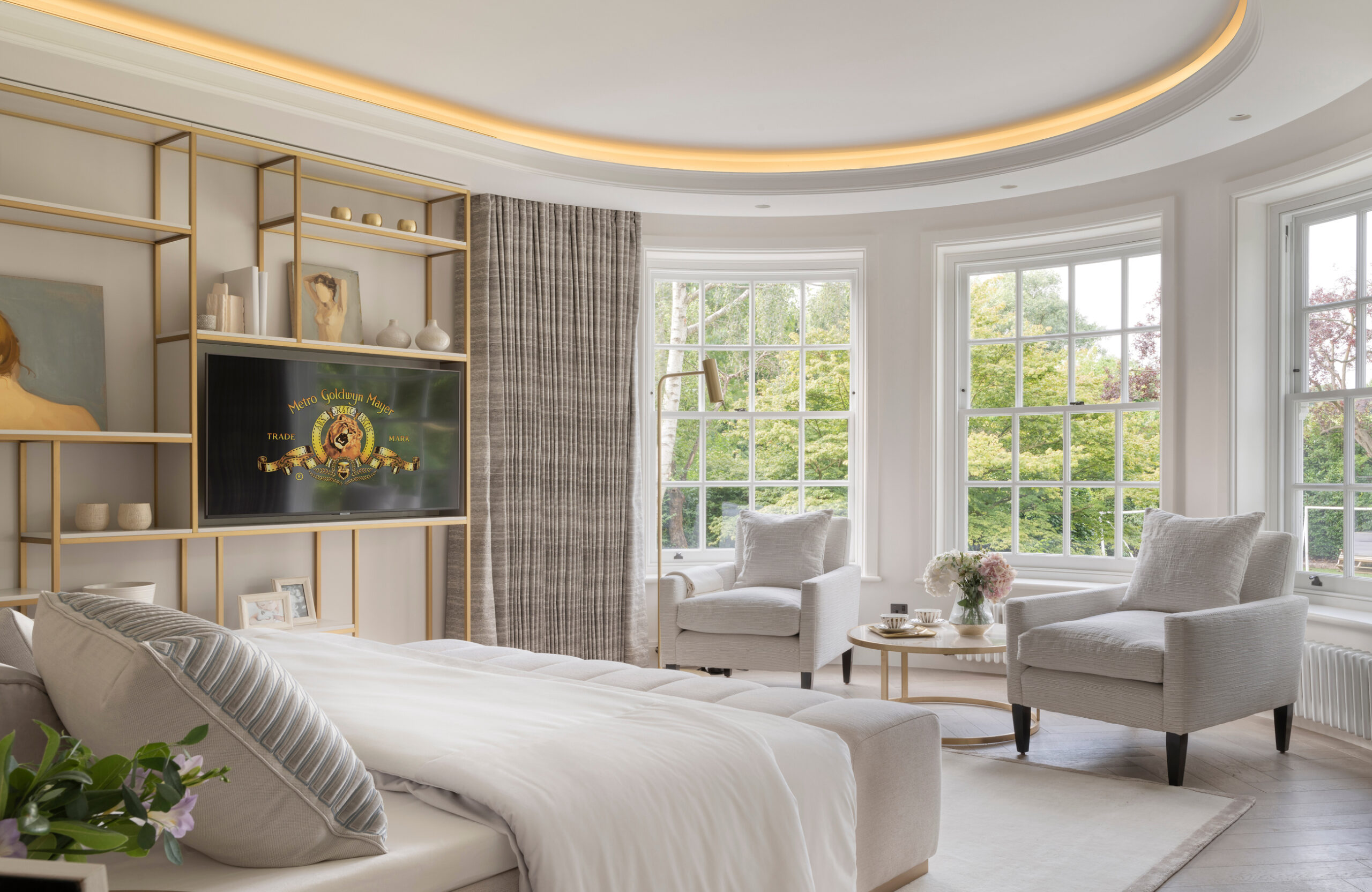 Master bedroom suite with curved sash window and illuminated coved ceiling