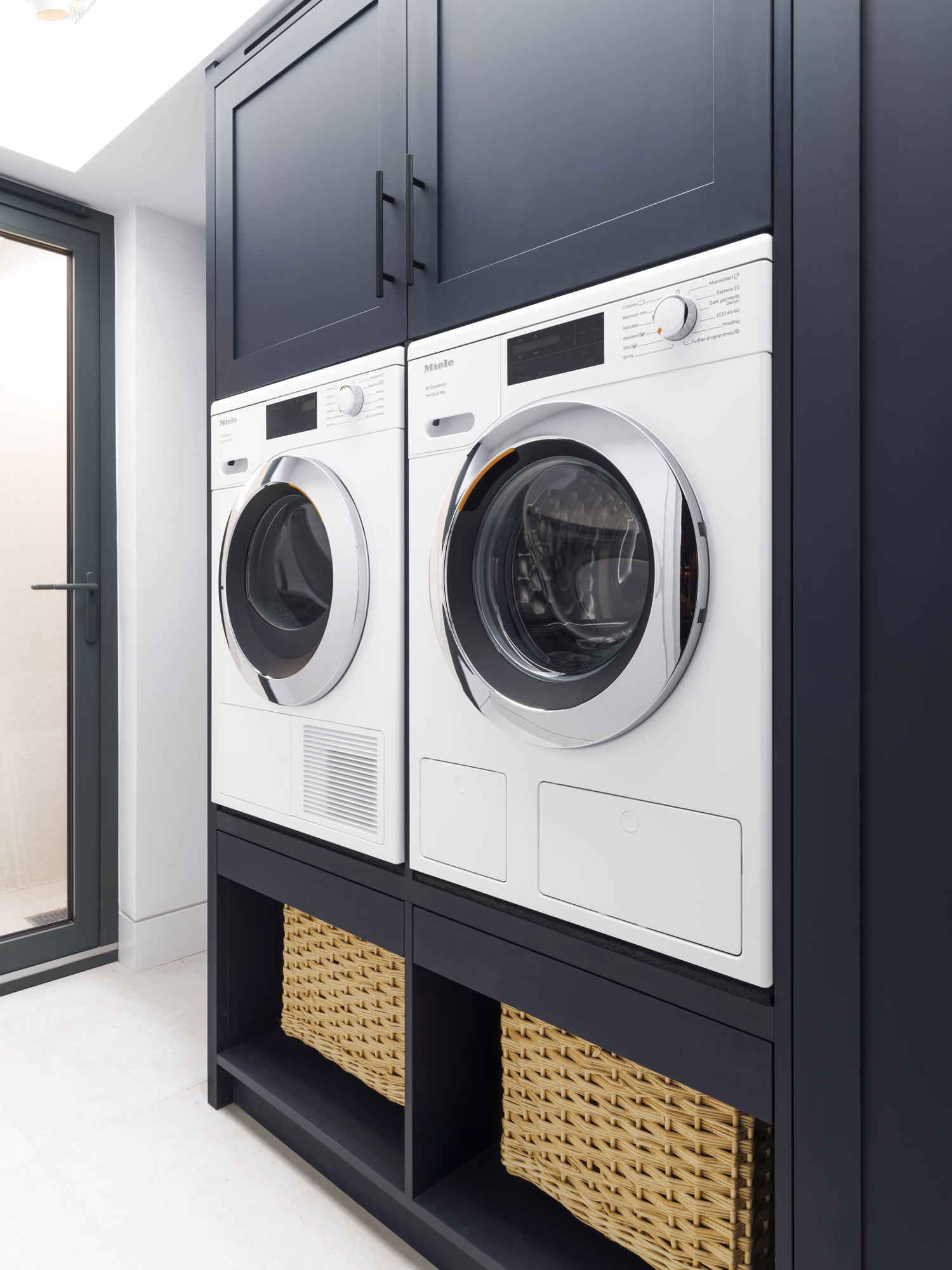 Chelsea Townhouse - LLI Design - Utility Room - Bespoke blue MFC joinery with integrated appliances and door to light well beyond