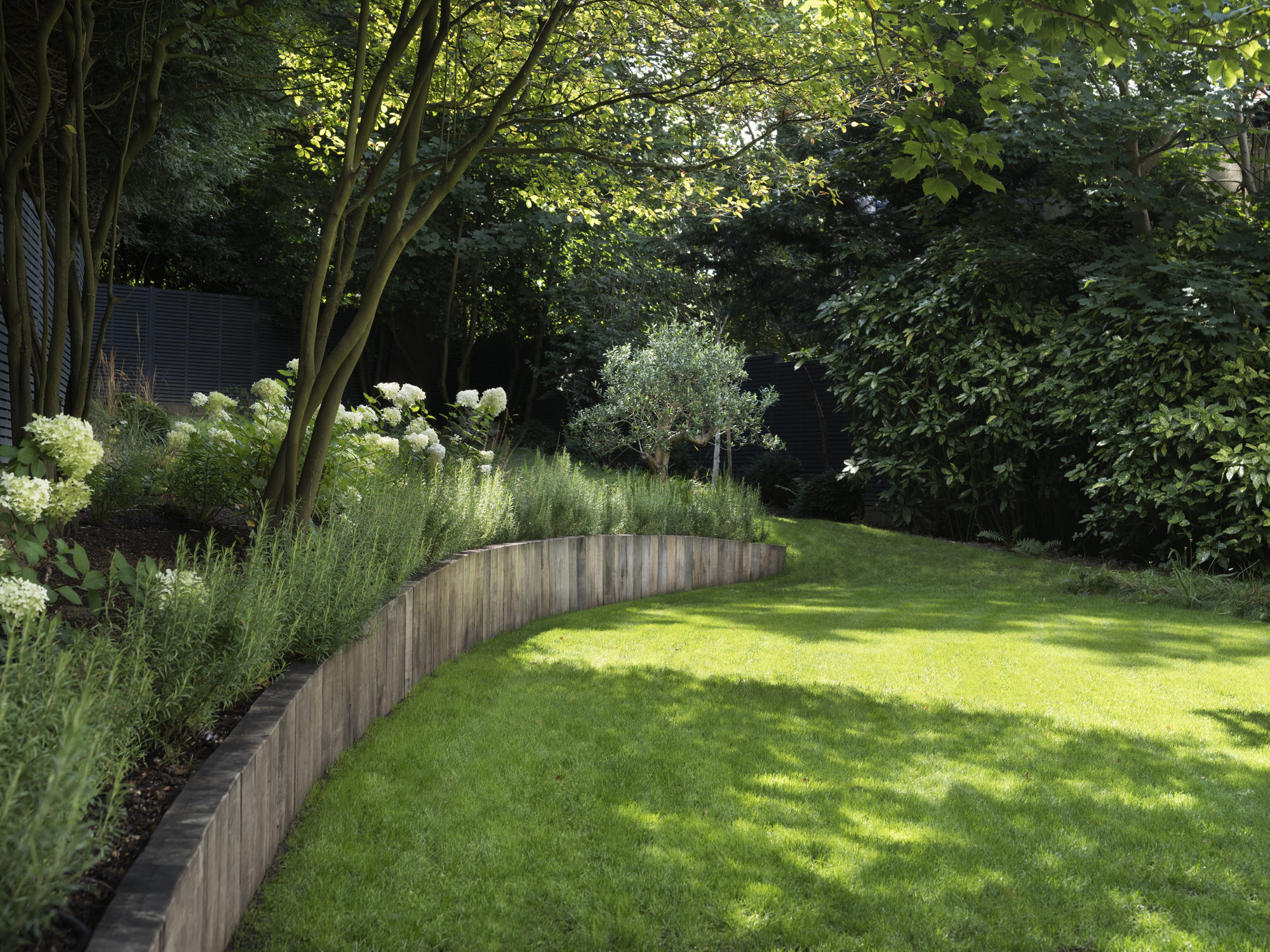 Highgate Minimal Modernism - LLI Design - Hard landscaping detail 2 with curved raised planter wall formed from sleepers
